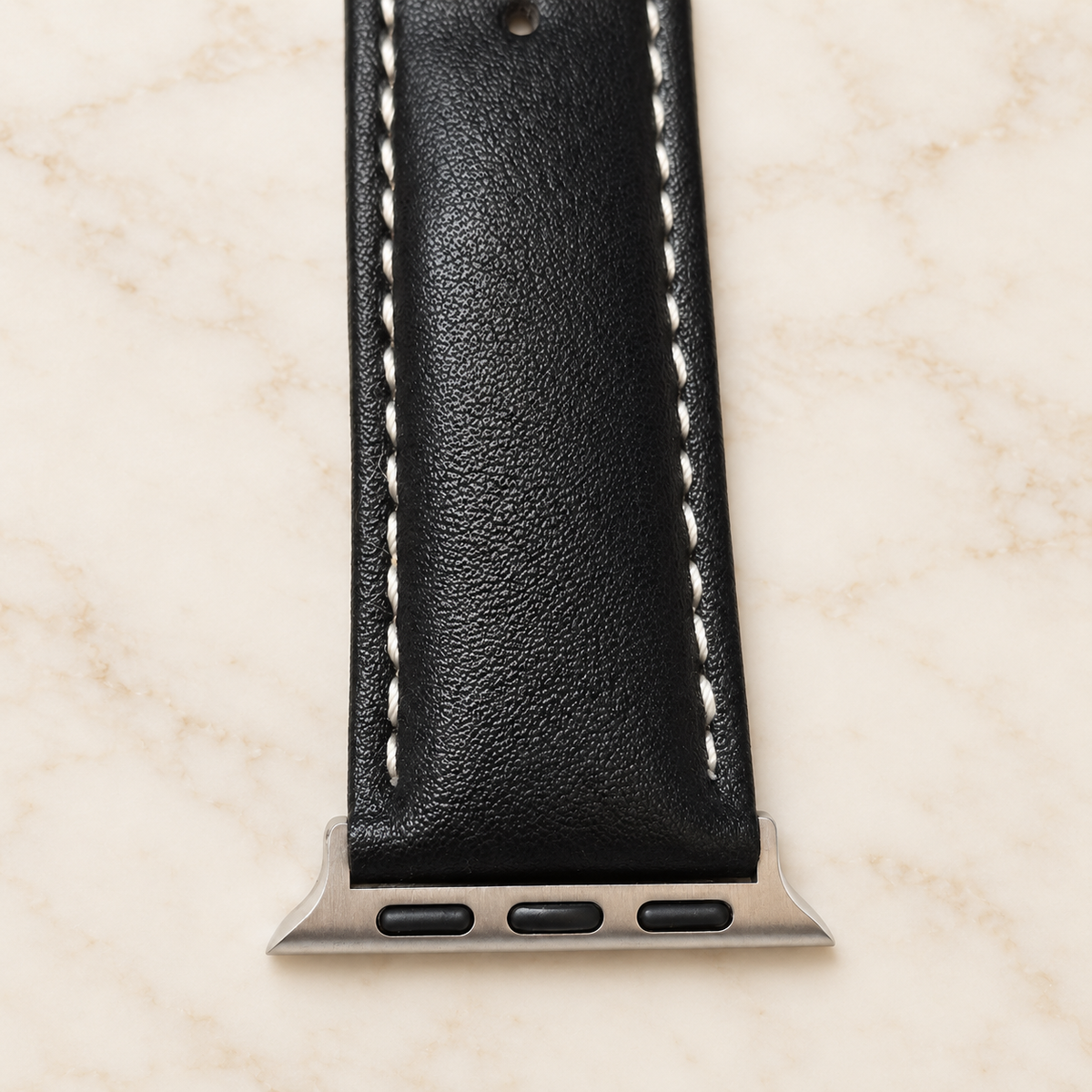 Connecteur métallique du bracelet Apple Watch noir surpiqué blanc