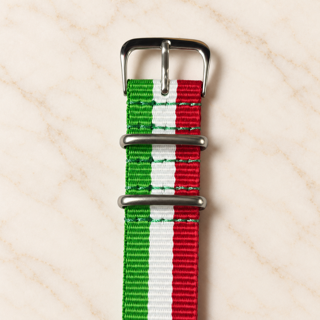 Détail de la boucle, des passants métalliques et des coutures du bracelet NATO vert, blanc et rouge