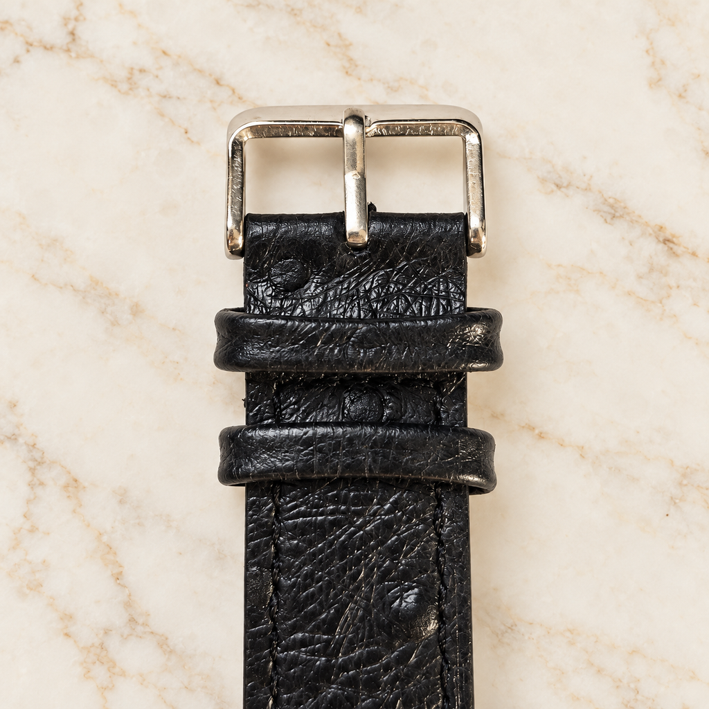Boucle argentée et passants du bracelet de montre noir en cuir